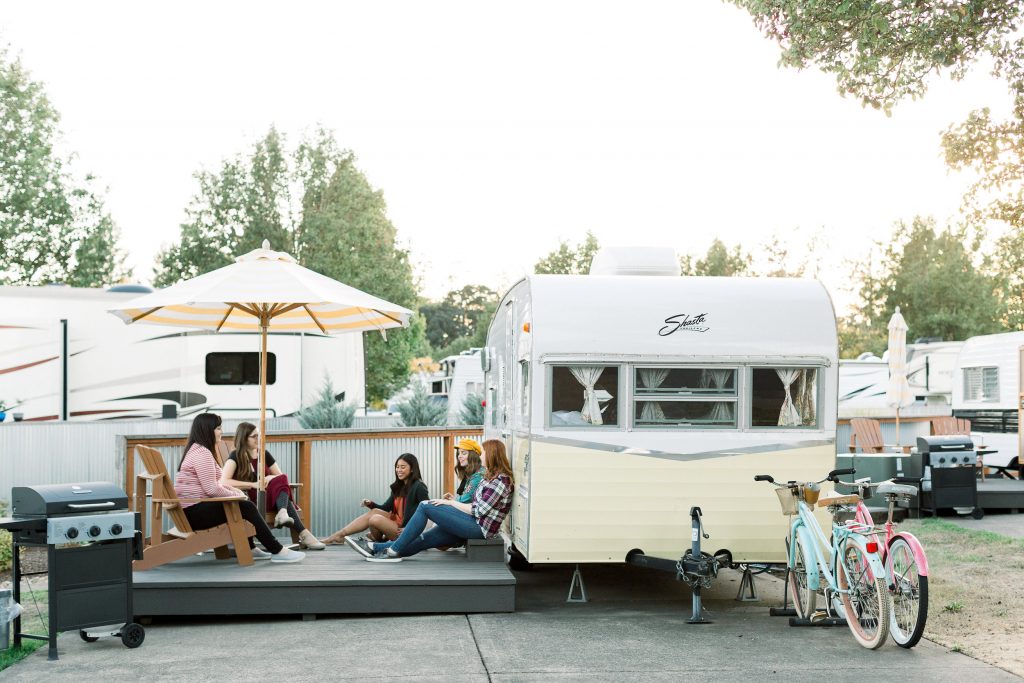 A group of women sitting on the patio on a sunny day at The Vintages Trailer Resort.