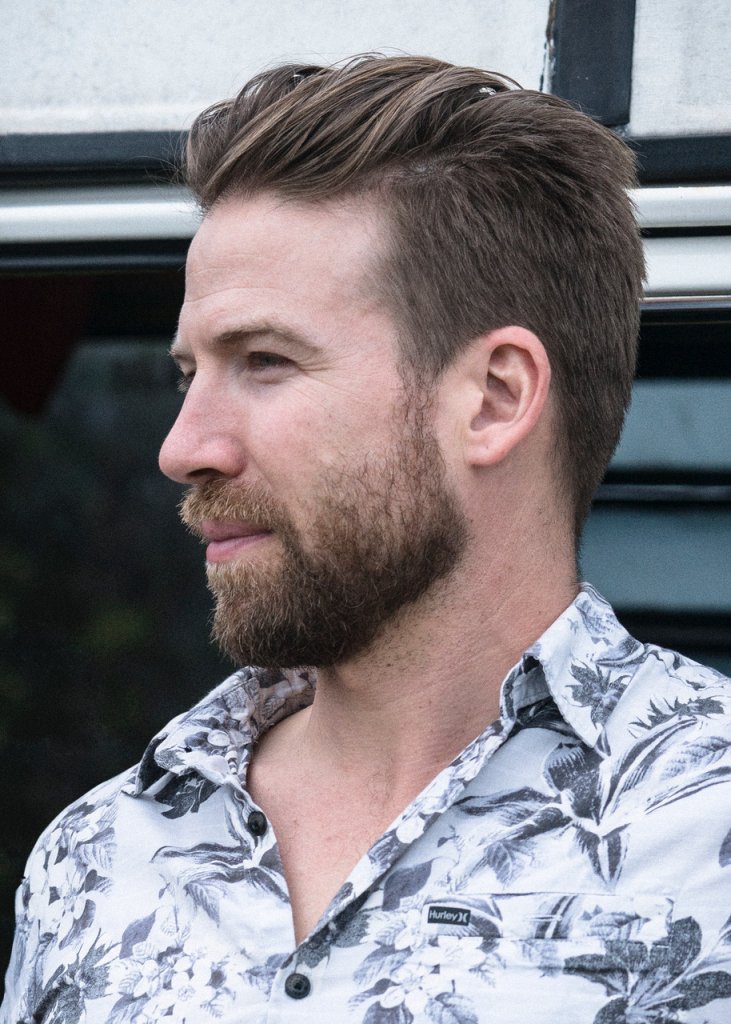 A side view picture of a man wearing a Hurley Hawaiian shirt. 